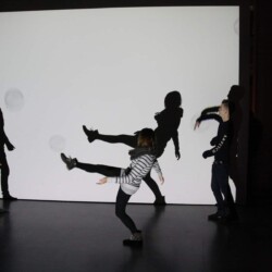 Schüler:innen der PHS üben vor einer weißen Leinwand Schattenspiele.